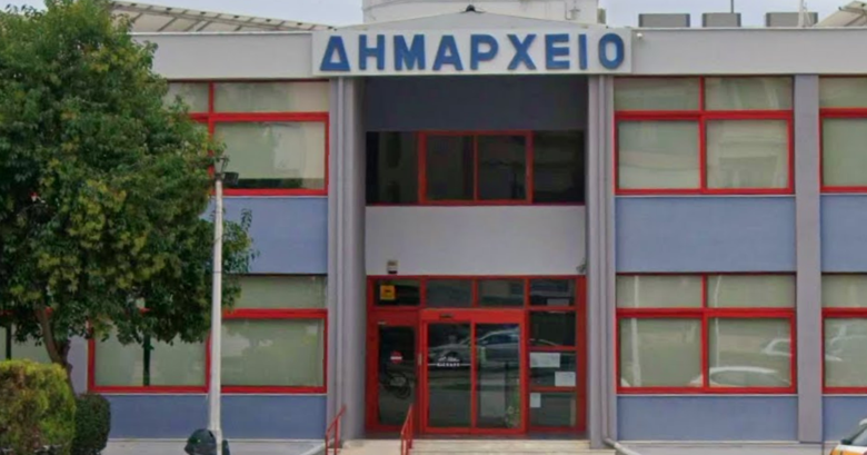 Κτίριο Δημαρχείου σε γκρι χρώμα με κόκκινες λεπτομέρειες γύρω από τα παράθυρα