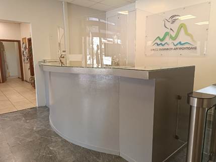 Γκρι, ψηλός πάγκος υποδοχής με προστατευτικό πλεξιγκλάς.