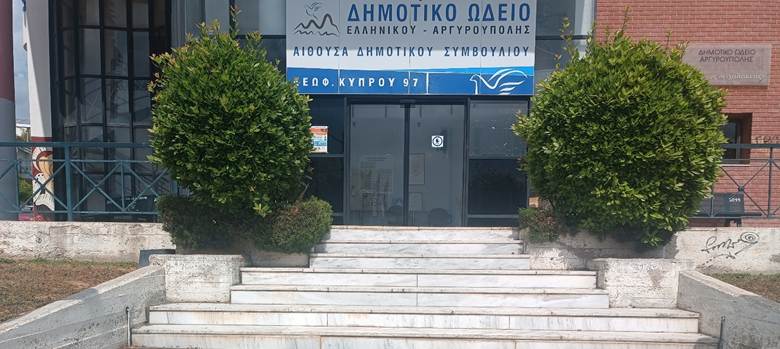 Μαρμάρινα σκαλοπάτια που οδηγούν σε γυάλινη αυτόματη θύρα με πινακίδα 'Δημοτικό Ωδείο, αίθουσα δημοτικού συμβουλίου'.